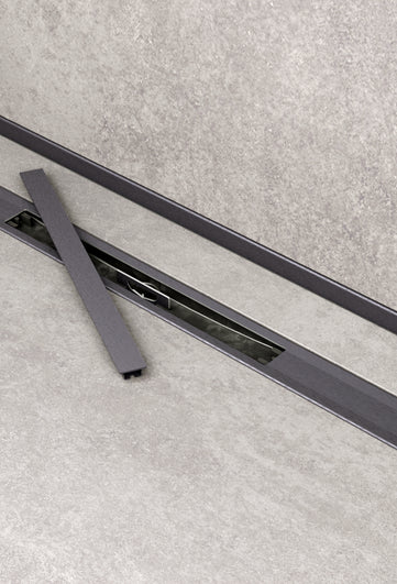 Duschrinne Pera als Ambientebild einer Duschnische.  Abdeckung für Zugang zum Siphon entnommen und neben liegend.